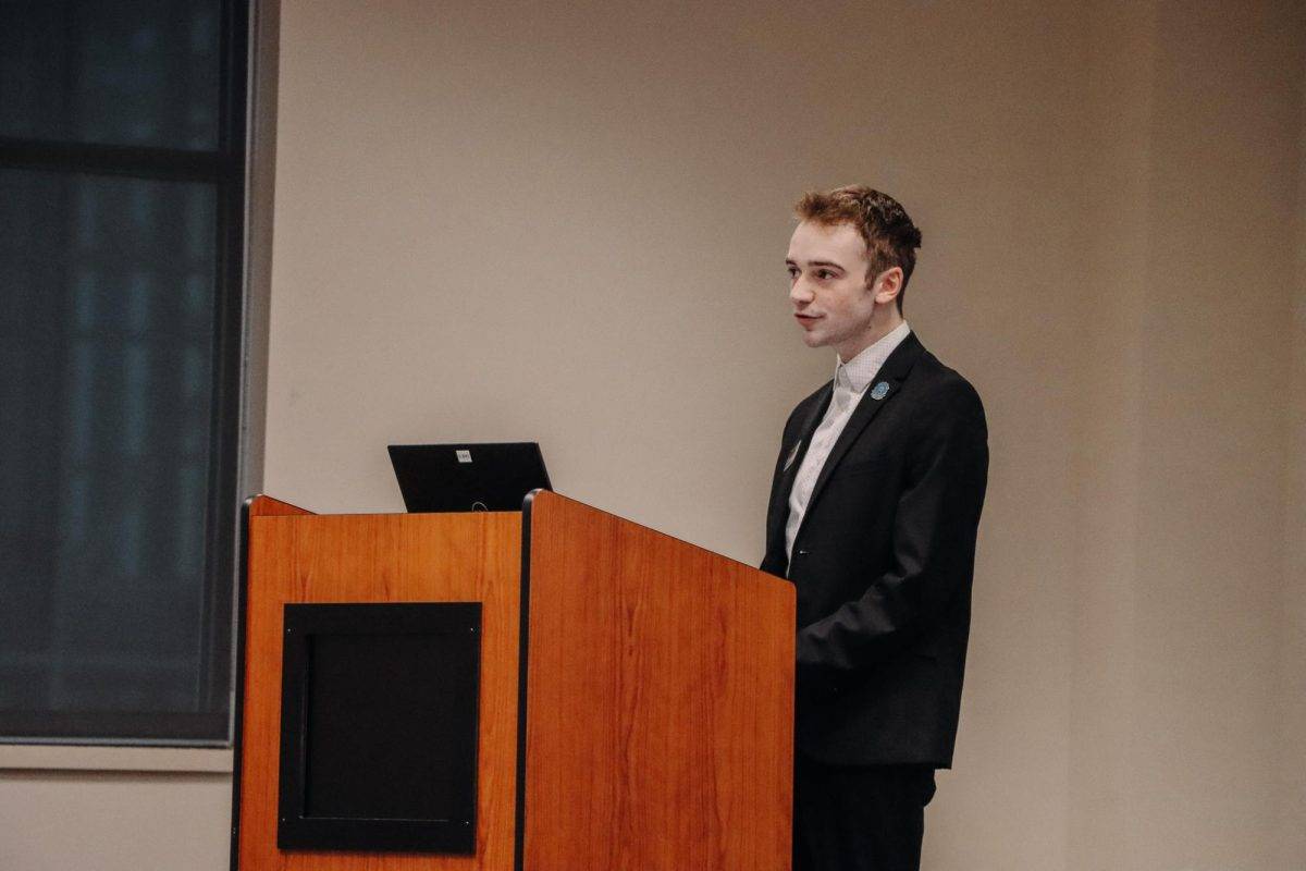 Student Senate president Quinten Proctor speaks from behind a podium